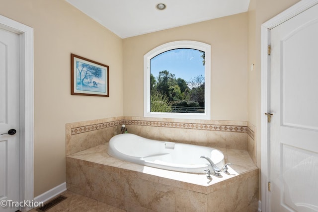 bathroom featuring tile patterned flooring and tiled bath