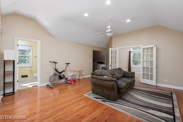 living room with ceiling fan, french doors, wood-type flooring, and vaulted ceiling