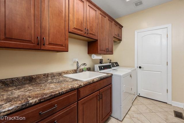 laundry area featuring cabinets, light tile patterned floors, washing machine and dryer, and sink