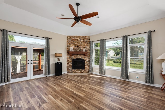 unfurnished living room featuring french doors, vaulted ceiling, ceiling fan, wood-type flooring, and a fireplace