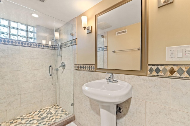 bathroom with an enclosed shower and tile walls