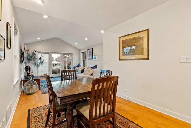 dining area with hardwood / wood-style flooring, lofted ceiling, and french doors