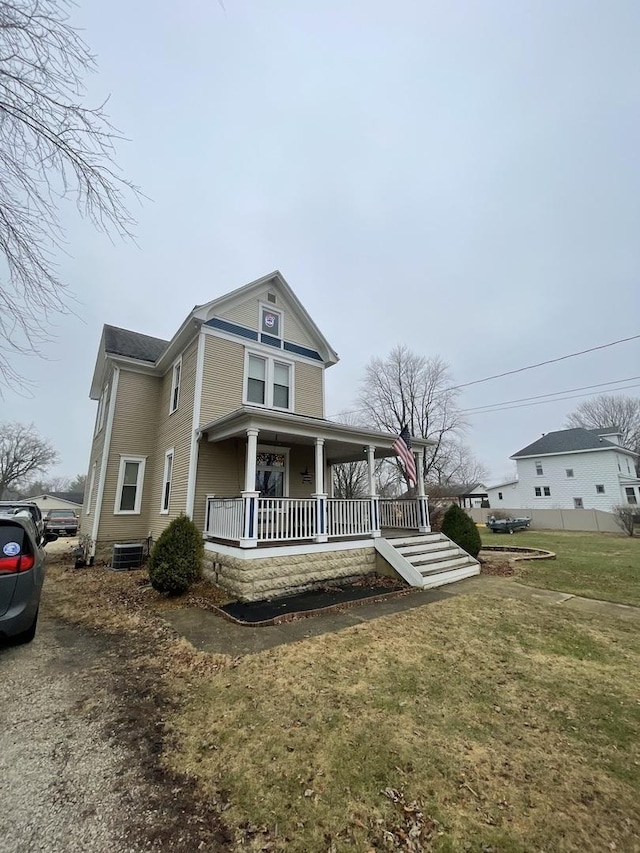 view of front of house featuring covered porch and a front lawn