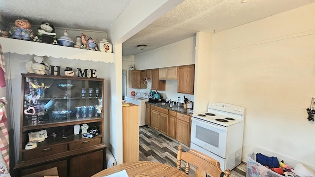 kitchen with a textured ceiling, electric range, washer / clothes dryer, and dark wood-type flooring