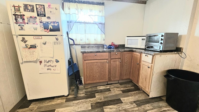 kitchen with white appliances and dark hardwood / wood-style floors