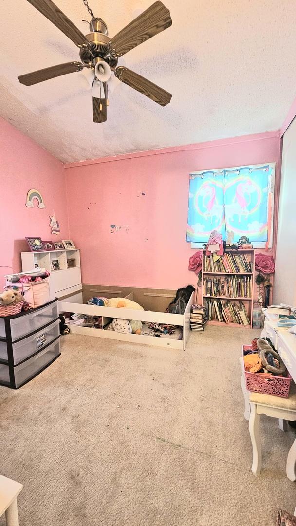 game room with carpet, a textured ceiling, and ceiling fan