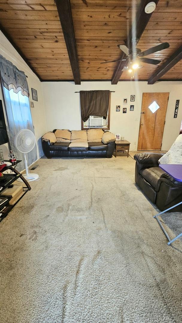 interior space with carpet flooring, lofted ceiling with beams, ceiling fan, and wood ceiling