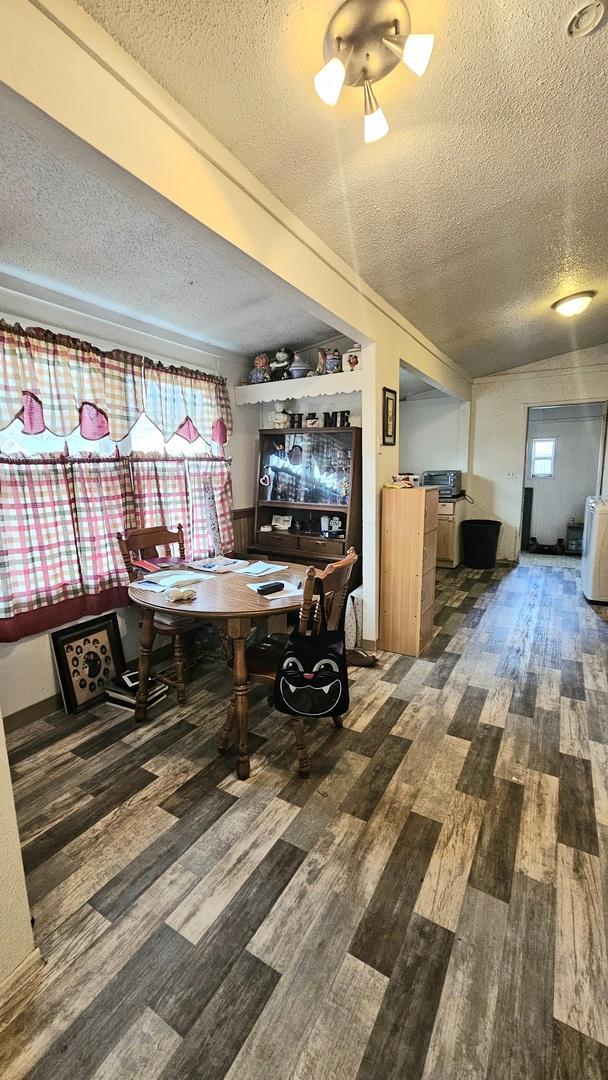 unfurnished dining area featuring hardwood / wood-style flooring and a textured ceiling