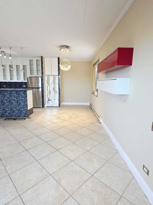 kitchen featuring tasteful backsplash, dark countertops, appliances with stainless steel finishes, wall chimney range hood, and light tile patterned floors