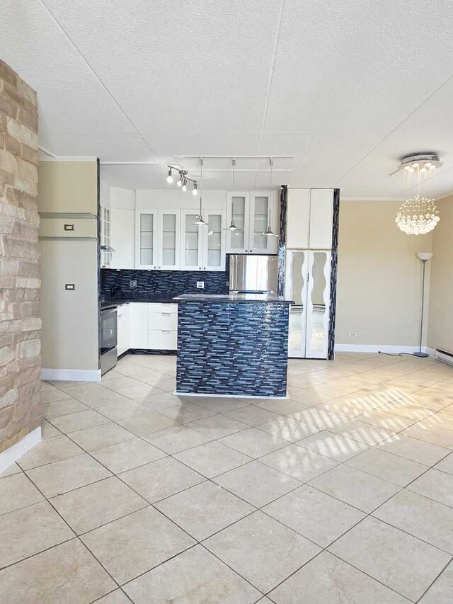 kitchen featuring dark countertops, light tile patterned floors, backsplash, and stainless steel appliances