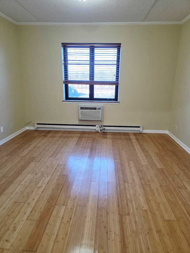 unfurnished bedroom featuring baseboards, light wood-style flooring, a closet, a walk in closet, and crown molding