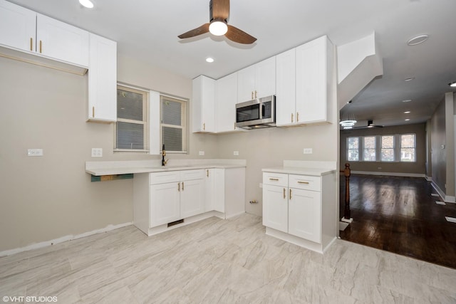 kitchen with white cabinetry, sink, ceiling fan, and light wood-type flooring