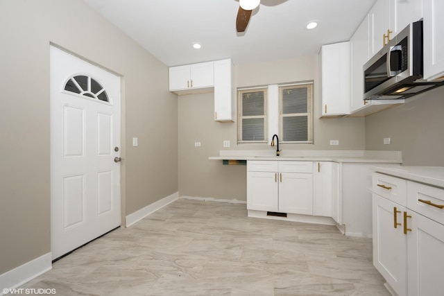 kitchen with white cabinetry, ceiling fan, and sink