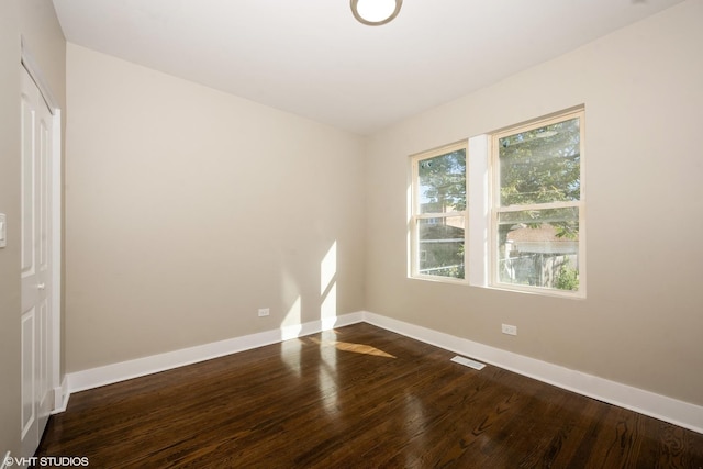 spare room featuring dark wood-type flooring