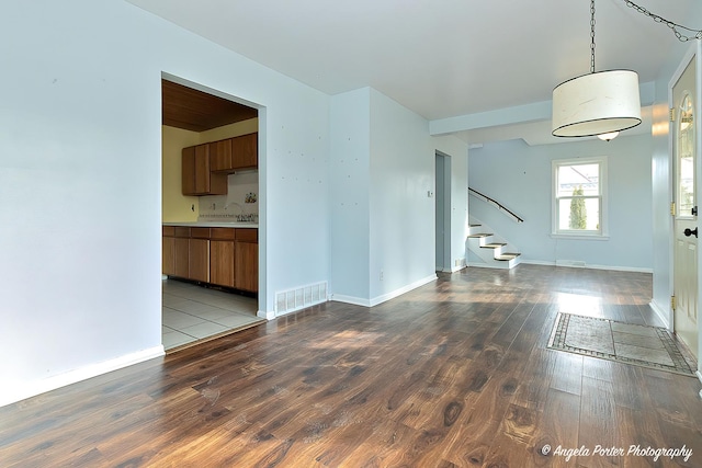 unfurnished living room with wood-type flooring and sink