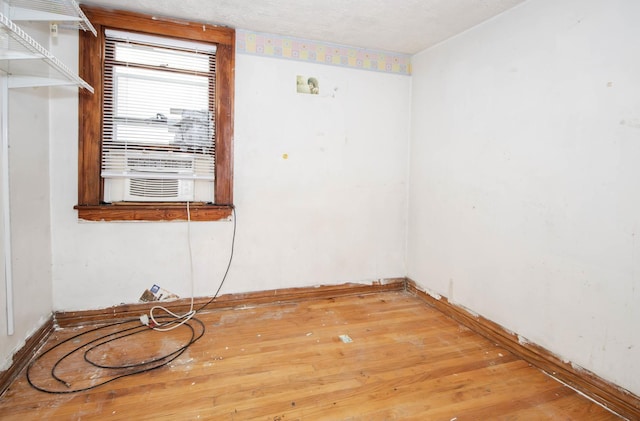 unfurnished room featuring cooling unit and light wood-type flooring