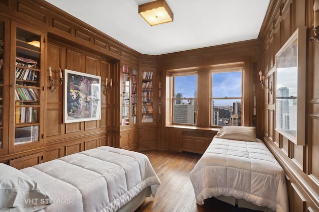 bedroom featuring light hardwood / wood-style floors and wooden walls