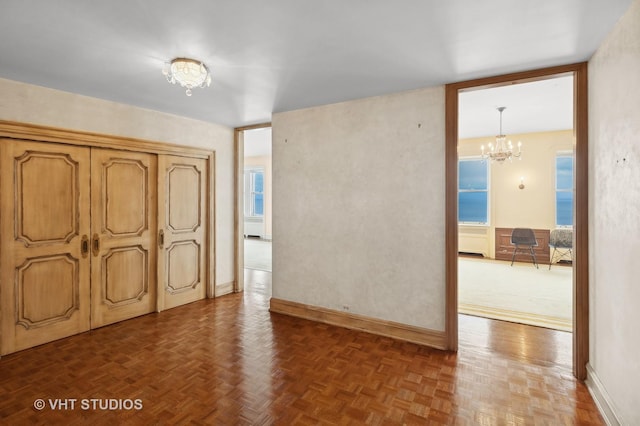 unfurnished bedroom featuring a chandelier and dark parquet floors