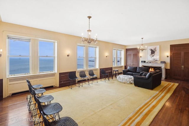 living room with carpet flooring, a notable chandelier, and a water view