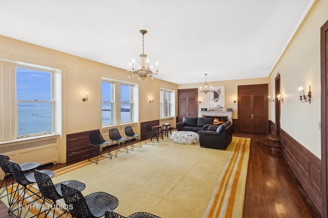 living room with a healthy amount of sunlight, a water view, and a notable chandelier