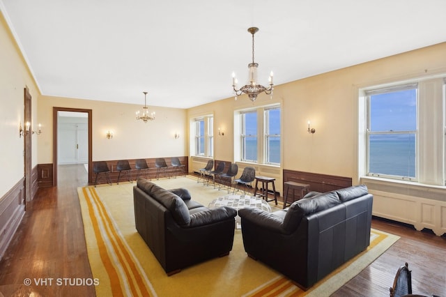 living room featuring a notable chandelier, a water view, and wood-type flooring