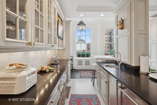 kitchen with dark hardwood / wood-style flooring, backsplash, crown molding, sink, and pendant lighting