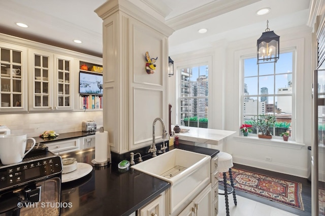 kitchen with crown molding, sink, hanging light fixtures, decorative backsplash, and a notable chandelier