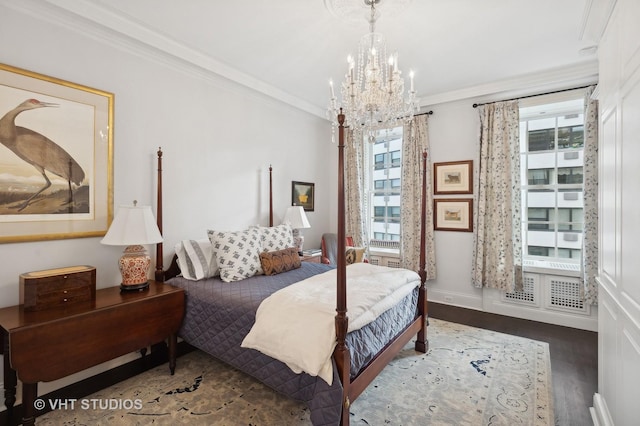 bedroom featuring dark wood-type flooring, ornamental molding, and a notable chandelier