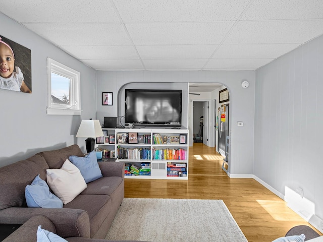 living room featuring a drop ceiling and wood-type flooring