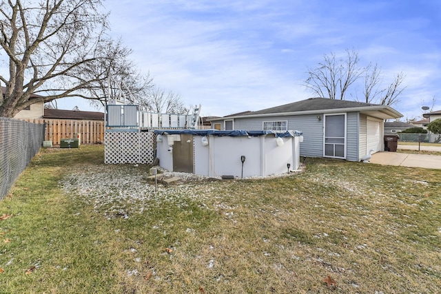 view of yard featuring a covered pool and a garage