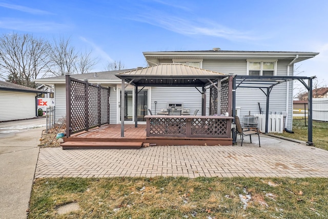 rear view of property featuring a gazebo, a pergola, and a deck