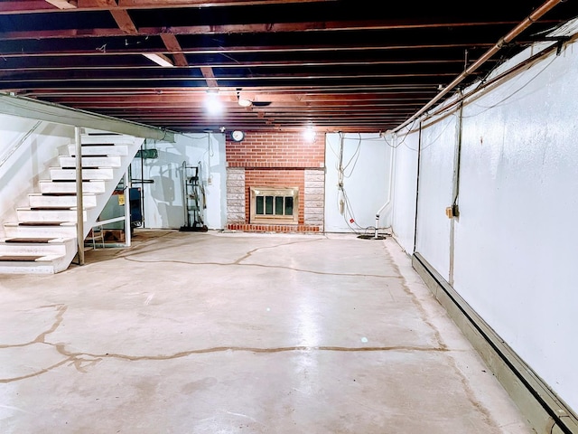 basement featuring a brick fireplace and baseboard heating