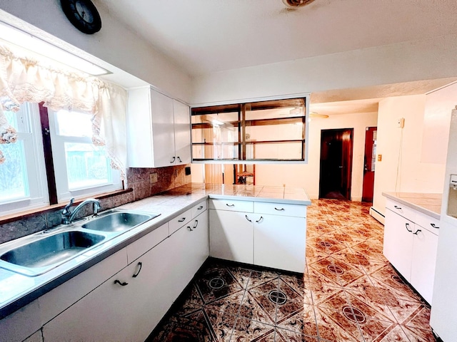 kitchen with white cabinets, tasteful backsplash, and sink