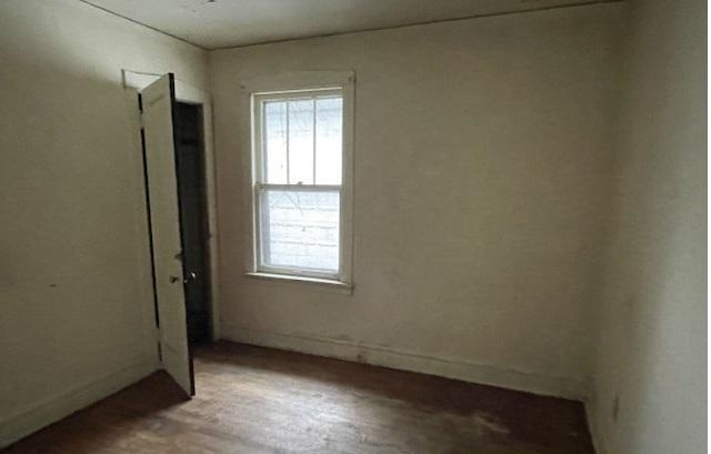 unfurnished room with hardwood / wood-style flooring