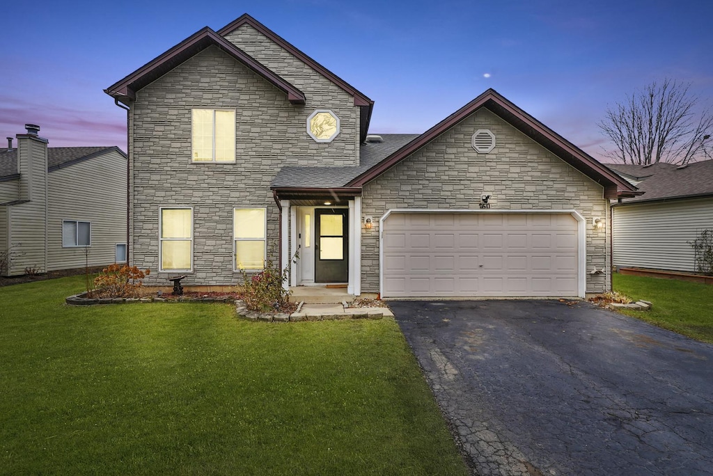 view of front of property featuring a garage and a lawn