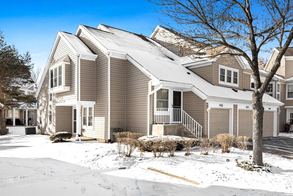 view of snowy exterior with a garage