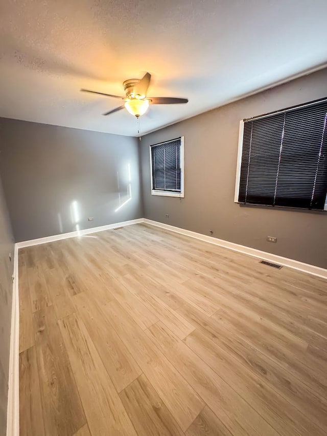 unfurnished room with ceiling fan and light wood-type flooring