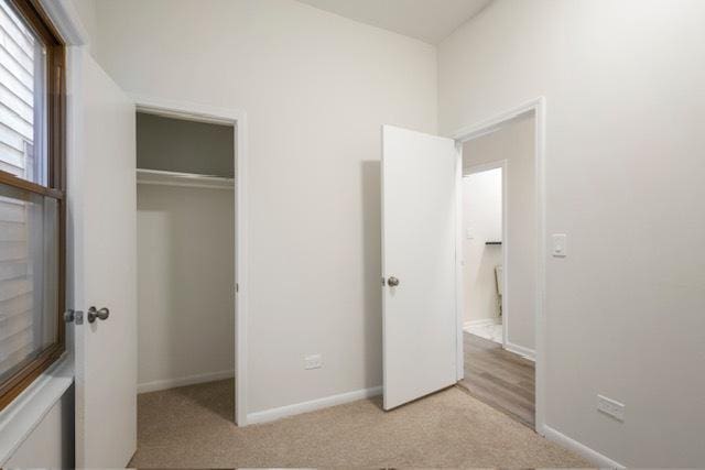 unfurnished bedroom featuring light colored carpet and a closet