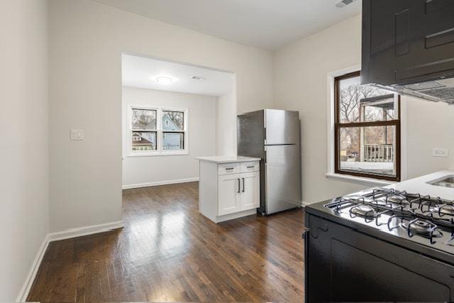 kitchen featuring white cabinets, stainless steel refrigerator, black range, and dark wood-type flooring