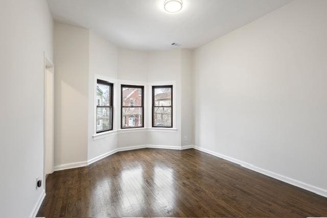 empty room with dark wood-type flooring