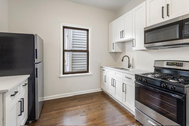 kitchen with white cabinets, stainless steel appliances, dark hardwood / wood-style floors, and sink