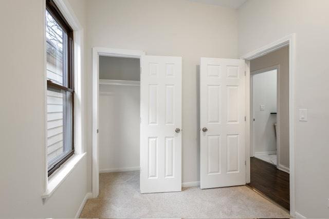 unfurnished bedroom featuring light carpet and a closet