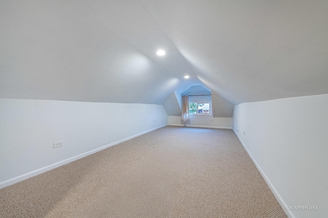 bonus room with light carpet and lofted ceiling