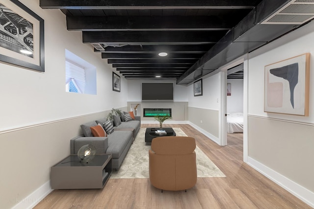 living room with beamed ceiling and light hardwood / wood-style floors