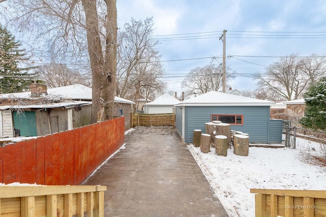 view of snow covered exterior featuring a garage and an outdoor structure