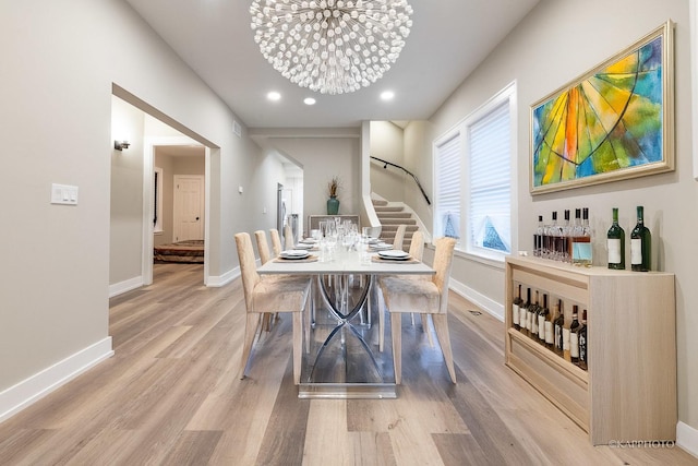 dining area with a chandelier and light hardwood / wood-style floors