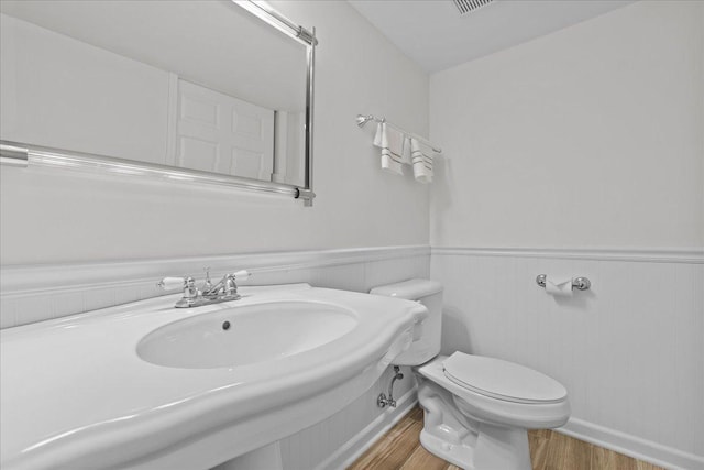 bathroom with hardwood / wood-style flooring, sink, and toilet