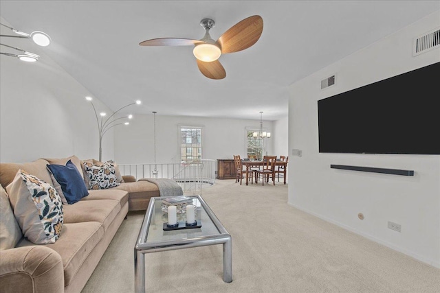 living room featuring ceiling fan with notable chandelier and light colored carpet