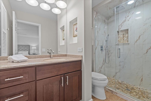 bathroom with tile patterned floors, vanity, an enclosed shower, and toilet