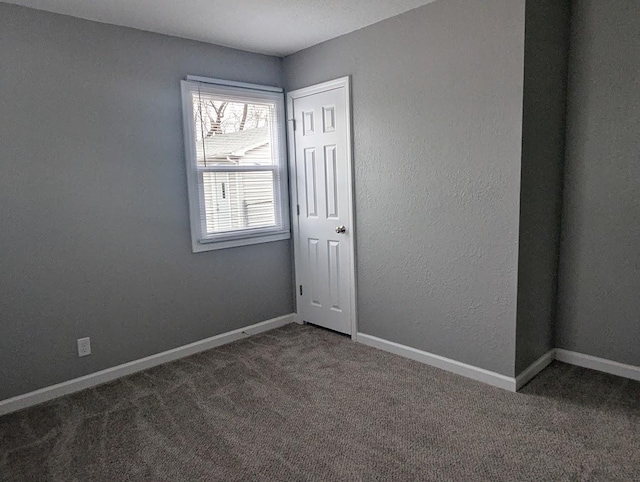 empty room with dark colored carpet